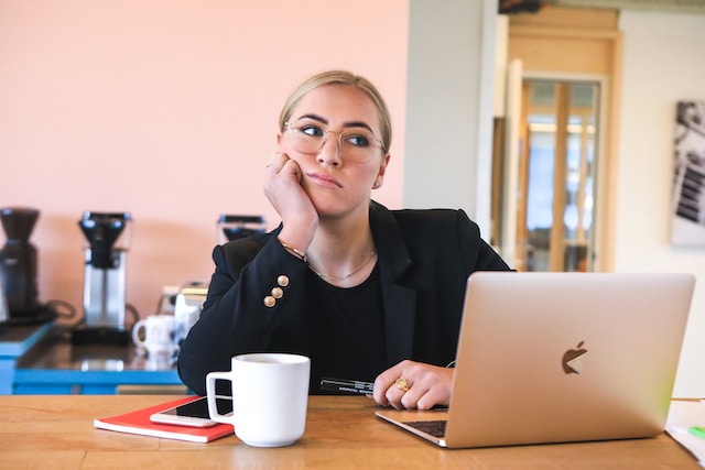 Woman thinking while working on her academic paper